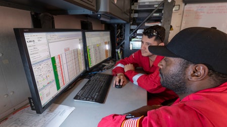 Halliburton employees working with the LOGIX real-time virtual logging tool.