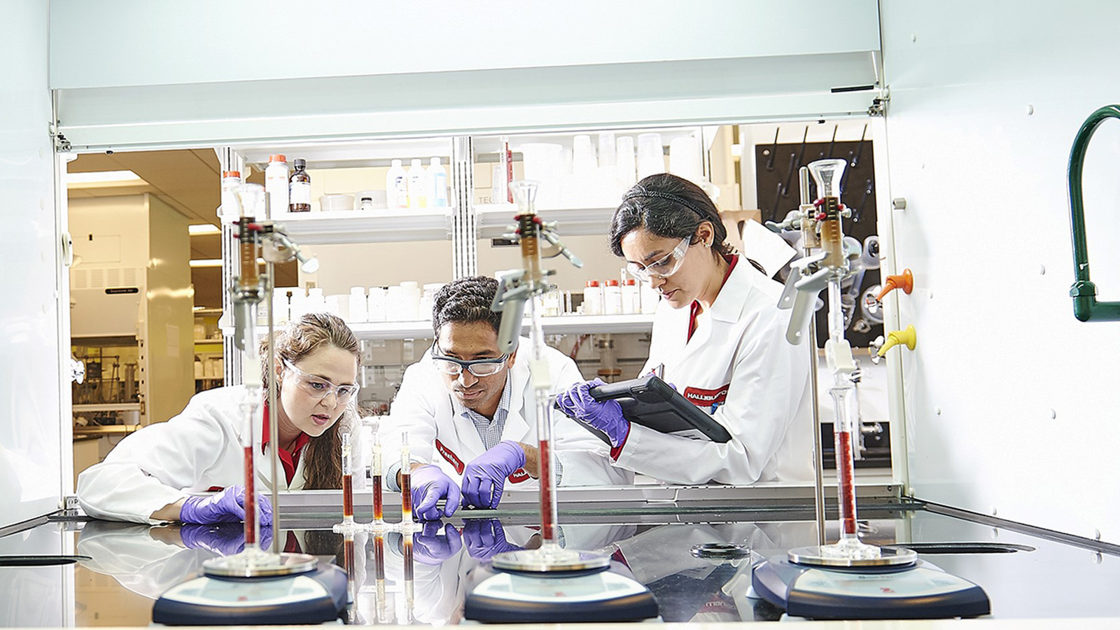 Lab technicians evaluating stimulation chemicals for additive compatibility.